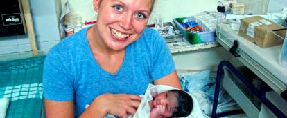 Projects Abroad intern hold a baby after observing the birth in a hospital in India. Nursing intern holds a newborn baby under the supervision of a local doctor in India.